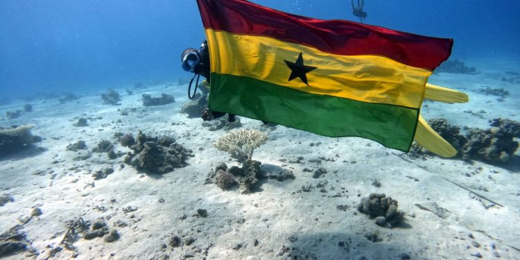 Diver, King David Nyamedor hoists Ghana flag under the Red sea